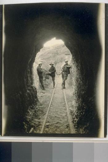 3 miners outside of a tunnel